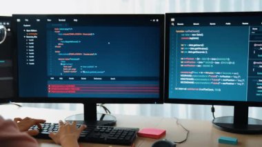 Yavaş çekim arkası yazılım geliştirici mühendisi bilgisayar programlama için birlikte çalışarak hata ayıklama kodunu çözüyor, ofiste monitörde karmaşık algoritmaları çözüyor. Filizlenen