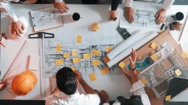 Yetenekli mühendis takımının ev modelini ölçerken konuştuğu tepeden tırnağa görüntü. Birlikte çalışan ve mühendislik inşaatı için plan yapan bir grup akıllı iç mimar. Hizalama.