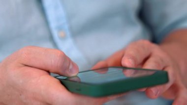 Orta yaşlı bir adam oturma odasındaki koltukta oturur telefon arama verilerini kullanır çocukları iyi bir yetişkin baba ya da eğlence olarak yetiştirir. İşadamı teknolojiyi kolaylık için kullanır. Uyumsuzluk.