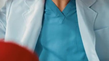 Hasta klinikte ya da hastane ofisinde doktor randevusuna gidiyor. Hastaların nabzını steteskopla kontrol edip risk faktörünü belirleyen doktor semptomları inceliyor. Panorama. Katı.