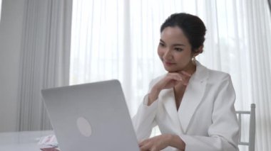 Çalışma masasında internet içeriği için dizüstü bilgisayar kullanan genç bir iş kadını ya da evden çalışan bir sekreter. Canlılık