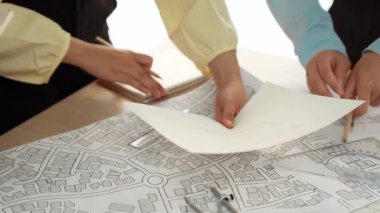 Akıllı mimar ya da akıllı mühendisin ölçüm aracı ve kalem el kullanarak mimari ofisindeki inşaat isabet planı üzerine detaylı bir yazı yazışının videosu. Eline odaklan. - Yakın çekim. Tanımlama.