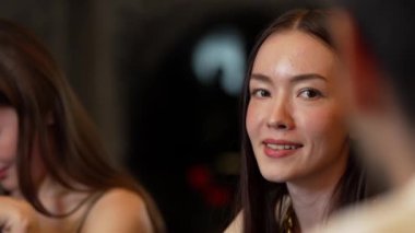 Lüks bir kokteyl barında grup arkadaşıyla gülümseyen güzel bir kadının portresi. Gece kulübünde sosyetik etkileşim için doğal yüz güzelliğini kostüm içinde yakalamak. Vinosity.