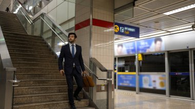 Profesyonel Kafkasyalı iş adamı metroya ya ya da iş yerine giderken gökyüzü trenine biniyor. Resmi takım elbise giyerken toplu taşıma vasıflı proje yöneticisi kullanıyor. İş çıkış saati. Sevinçli..