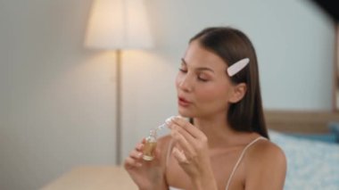 Sosyal medya için güzellik ve kozmetik video içeriği hazırlayan genç bir kadın. Güzellik blogcusu kameraya gülümserken seyircilere ve takipçilere güzellik bakımını gösteriyor. Düzenle