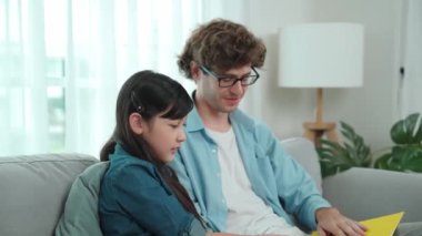 Beyaz bir baba ve tatlı bir kız kanepede otururken masal kitabı okuyorlar. Mutlu bir baba, sevimli bir Amerikan çocuğuna, birlikte zaman geçirirken hayal gücünün gelişmesi için hikaye anlatıyor. Pedagoji.