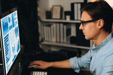 Akıllı iş adamı iş paragrafı dinamik pazarlama analizi planını analiz ediyor. Kağıt kağıtları ve bilgisayar monitörü raporlarını gece evdeki belge verileriyle karşılaştırmak için hazırlıyor. Bireysel.