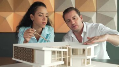 Profesyonel mimar mühendis takımı ev modeli inşaatı hakkında konuşuyor. Ev malzemesi ve yapı sorunları konusunda uzman proje yöneticisi beyin fırtınası yapıyor. İş tasarımı konsepti. Yönlendirici.