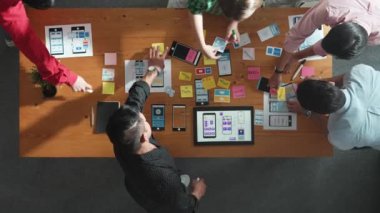 Mobil telefon arayüzü için Ux Ui tasarımı planlarken iş adamlarının yapışkan notlar üzerine yazı yazma fikrine tepeden aşağı bakış açısı. Bir grup yaratıcı tasarımcı kablo prototip tasarımı üzerinde çalışıyor. Cemaat.