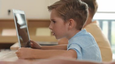 Bilgisayar üzerinde çalışan beyaz çocuğun yan görüntüsü. Mühendislik ödevi sırasında. Çekici çocuklar bilgisayar yazılımı kullanarak yapay zeka ya da programlama sistemini öğreniyor ya da öğreniyor. Pedagoji.