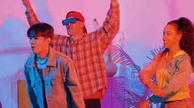 Break dansçı takımının modern stüdyoda pembe ışıkla dans etmesini kapatın. Çok kültürlü insanlar moda kıyafetleri giyerek hip hop müziğine geçiyorlar. Çılgın, komik bir ruh hali. Mutluluk.