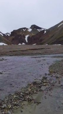 İzlanda, Avrupa 'nın dağlık kesimlerindeki Landmannalaugar gerçeküstü doğa manzarasının insansız hava görüntüleri. Güzel rengarenk kar dağı arazisi yaz gezileri ve açık hava maceralarıyla ünlüdür..