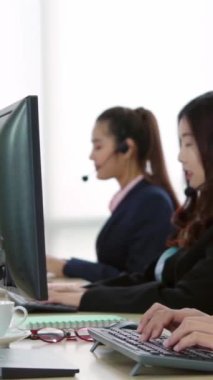 Ofiste çalışan kulaklık takan işadamları uzak müşteri ya da meslektaşlarını desteklemek için çalışıyorlar. Arama merkezi, tele pazarlama, müşteri destek acentesi telefon görüşmesinde hizmet sunar.