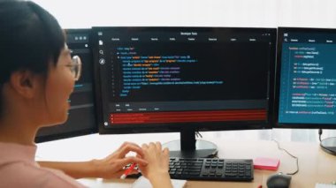 Yavaş çekim arkası yazılım geliştirici mühendisi bilgisayar programlama için birlikte çalışarak hata ayıklama kodunu çözüyor, ofiste monitörde karmaşık algoritmaları çözüyor. Filizlenen