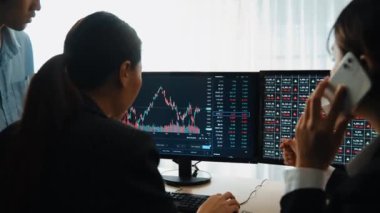 Menkul kıymetler borsası pazarlamasını inceleyen borsa yatırımcıları, zarar ve kazanç için mum bar fiyatlarını analiz eden monitörlere bakıyor. Filizlenen