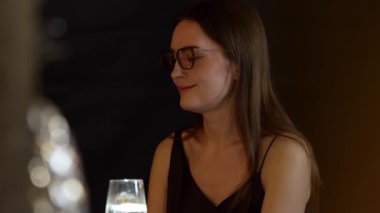 Güzel bir kadının portresi, lüks bir tezgah içecek barında arkadaşlarıyla sohbet edip, dilimlenmiş portakallı gazoz içerken. Kulüpte sosyetenin özünü yakalamak. Vinosity.