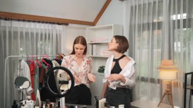 İki kadın nüfuzlu partner sosyal medya veya blog için canlı yayın yapan video klip inceleme derisi çekiyorlar. Kozmetik stüdyosu ışıklandırması olan genç bir kız pazarlama oturumu çevrimiçi yayın yapıyor.