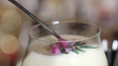 Kapalı tutku meyveleri ve üzerine pembe çiçek eklenerek süslenmiş tatlı likör kokteyli, alkol serinletici vitrin odaklı reklamı için özel yaratıcı içecek menüsü listesi oluşturuyor. Vinosity.