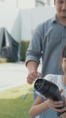 Elektrikli araç şarj istasyonu olan, sağlıklı ve temiz bir çevreyi teşvik eden yenilikçi bir aile kavramı. Sürdürülebilir, temiz enerji teknolojisiyle çalışan elektrikli araç..