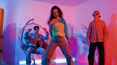 İspanyol hipster renkli kıyafetler giyer ve serbest stil müziğe el sallar. Profesyonel break dansçı neon ışıklarıyla ve modern stüdyo arkadaşlarıyla coşkuyla dans ediyor. Mutluluk.