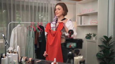 Kadın nüfuzlu kişi video görüntülerini canlı yayınlıyor. Kıyafetler sosyal medyada ya da blogda yer alıyor. Stüdyo ışıklandırmalı mutlu genç kız çevrimiçi pazarlama oturumu yayını için..