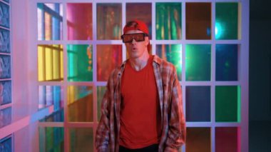 Serbest stil tişört giyerken sokak müziği çalan mutlu hipster. Gece kulübünde neon ışıkla dururken çekici break dansçı dans ve hareketli hareketler yapıyor. Mutluluk.