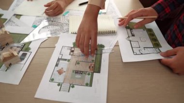 Akıllı mimar ya da akıllı mühendisin ölçüm aracı ve kalem el kullanarak mimari ofisindeki inşaat isabet planı üzerine detaylı bir yazı yazışının videosu. Eline odaklan. - Yakın çekim. Tanımlama.