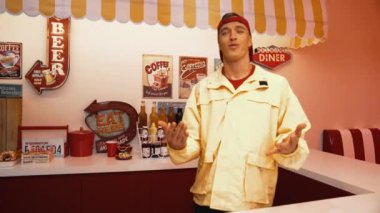 Kafkasyalı restoran çalışanı dans ederken ve serbest stil müzik eşliğinde dans ederken sofraya yemek koyarken mutlu ol. Profesyonel yetenekli garson yemek barının arkasında beklerken müşteriler için yemek hazırlar. Mutluluk.