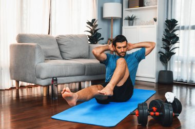 Atletik ve sporcu adam, evde vücut egzersizi yaparken spor ve spor yaşam tarzına uyum sağlamak için spor minderinde çatırdıyor. Gaiety ev egzersizi antrenman konsepti.