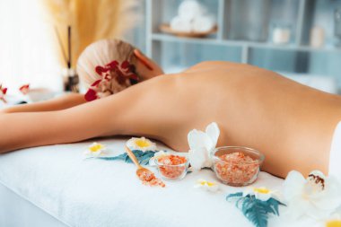 Lüks spa salonlarında sıcak mum ışığında cilt bakımı yaptıran kadın müşteri. Sağlık Spa vücut fırçasında tuz temizleme güzellik tedavisi. Sessiz.