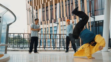 Hip hop takımı dans molası verirken, çok kültürlü bir arkadaş arkadaşını alkışlıyor ve alkışlıyor. Aktif ve enerjik sokak dansı. Açık hava sporu 2024 hiphop..