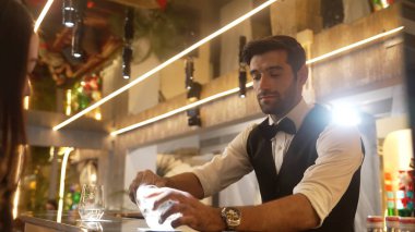 Lüks barlarda cin kokteyli ya da tonik servisi yapan akıllı barmenlere odaklanırken, arka plandaki VIP müşterilerle sıcak gece kulübünün ışıklandırma atmosferinde canlı sohbetler yapıyorlar. Vinosity.