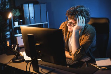 Stresli yaratıcı yönetici yeni sunumla tasarım araması yaparken ev ofisteki dizüstü bilgisayarlı ekranda gece vakti neon lambalı bir odada e-posta göndermeyi bekliyor. Toplayıcı.