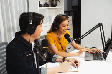 Gülümseyen radyo etkili sunucular, kulaklık takarak sosyal medya kanalından canlı yayın yapıyorlar ve sabah saatlerinde stüdyo kaydında dinleyicilere konu ve dizüstü bilgisayar üzerinden konuşuyorlar. İnfobahn.