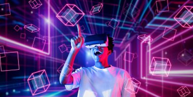 VR gözlük takan zeki bir genç ve geometrik şekil konusunda heyecanlı. Afrikalı oyuncu gündelik kıyafet giyiyor ve artırılmış gerçeklik teknolojisi kullanırken parlak ışık rengiyle çevrili. Yaratıcılık.