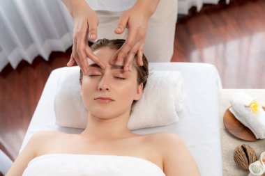 Kafkasyalı kadın stres önleyici kafa masajından ve lüks tatil beldesi ya da otel spa salonundaki modern ışık ortamında yüz güzelliği eğlencelerini şımartmaktan hoşlanıyor. Sessiz.