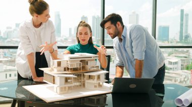 Dizüstü bilgisayar kullanırken mühendis ekibiyle usta mimar tartışmalarının portresi. Bir grup iş adamı beyin fırtınası ve bina inşaatı yapıyor. İnşaat mühendisliği, birlikte çalışıyoruz. İzleme