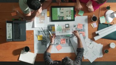 Toplantıda tablet kullanarak iç mimar planlama binasının üst hava görüntüsü. Bir grup mimar mühendis, fikir üretme ve ev yapısını tasarlama işini yönetime sunarken. Sempozyum.