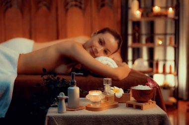 Aromaterapi masajı ambiyansı ya da spa salonu kompozisyon düzeneği bulanık kadınlara odaklı dekor mumları ve spa aksesuarları ile tatil köyü veya otel arka planında keyifli aroma spa masajı yapan. Sessiz.
