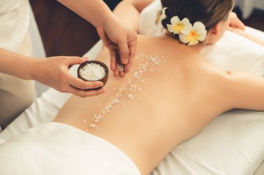 Lüks spa salonlarında sıcak mum ışığında cilt bakımı yaptıran kadın müşteri. Sağlık Spa vücut fırçasında tuz temizleme güzellik tedavisi. Sessiz.