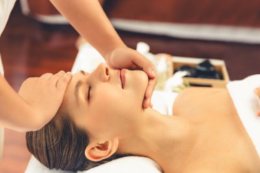 Kafkasyalı kadın stres önleyici kafa masajından ve lüks tatil beldesi ya da otel spa salonundaki modern ışık ortamında yüz güzelliği eğlencelerini şımartmaktan hoşlanıyor. Sessiz.