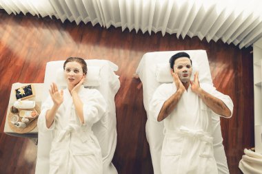 Kaplıca salonunun sakin, modern gündüz atmosferi, birkaç müşteri yüz maskesi takarak kendini yenilemeye çalışıyor. Yüz bakımı ve güzellik kozmetolojisi prosedürü. Sessiz.