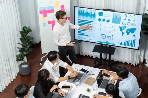Ofiste sunum ya da analist ekibiyle toplantı odasında mali verileri analiz etmek için BI Fintech 'i kullanmak. İş adamları stratejik planlama için TV ekranında BI gösterge panelini inceliyor.