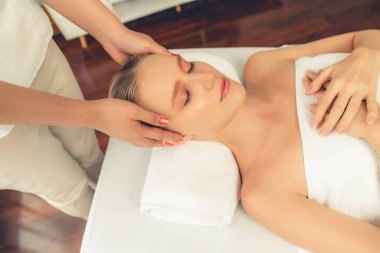 Kafkasyalı kadın stres önleyici kafa masajından ve lüks tatil beldesi ya da otel spa salonundaki modern ışık ortamında yüz güzelliği eğlencelerini şımartmaktan hoşlanıyor. Sessiz.