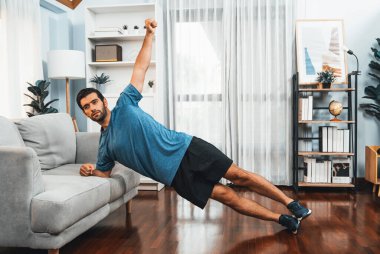 Atletik vücut ve aktif sporcu, sağlıklı vücut çalışma yaşam tarzı konsepti olarak neşeli ev egzersizlerinde kas kazanma egzersizi yapmak için mobilyaları kullanıyor..