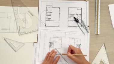 Akıllı mimar ya da akıllı mühendisin ölçüm aracı ve kalem el kullanarak mimari ofisindeki inşaat isabet planı üzerine detaylı bir yazı yazışının videosu. Eline odaklan. - Yakın çekim. Tanımlama.