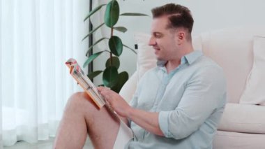 Kanepede oturan orta yaşlı bir adam, sosyal ve teknolojik mesleki gelişmeler hakkında ders kitabı okur ya da çocukları iyi bir yetişkin baba olmak için yetiştirir. Hayat boyu öğrenme konsepti. Uyumsuzluk.