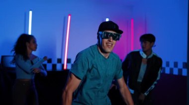 Kameranın önünde dans eden yetenekli break dansçı farklı arkadaşları pop ya da hip hop müziği dinlemek için arkada dans ediyor. Çekici performans ekibi kameraya doğru hareketli hareketler sergiliyor. Mutluluk.