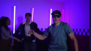 Kameranın önünde dans eden yetenekli break dansçı farklı arkadaşları pop ya da hip hop müziği dinlemek için arkada dans ediyor. Çekici performans ekibi kameraya doğru hareketli hareketler sergiliyor. Mutluluk.