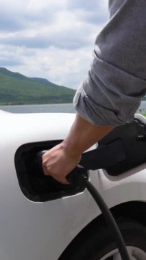 Çevre dostu seyahat ya da otomobil alternatif enerji teknolojisiyle çalışan EV arabasıyla tatil tatili olarak özgeçmişi ve doğası gereği elektrikli arabaya akıllı EV şarj cihazı takın. İnceleyin